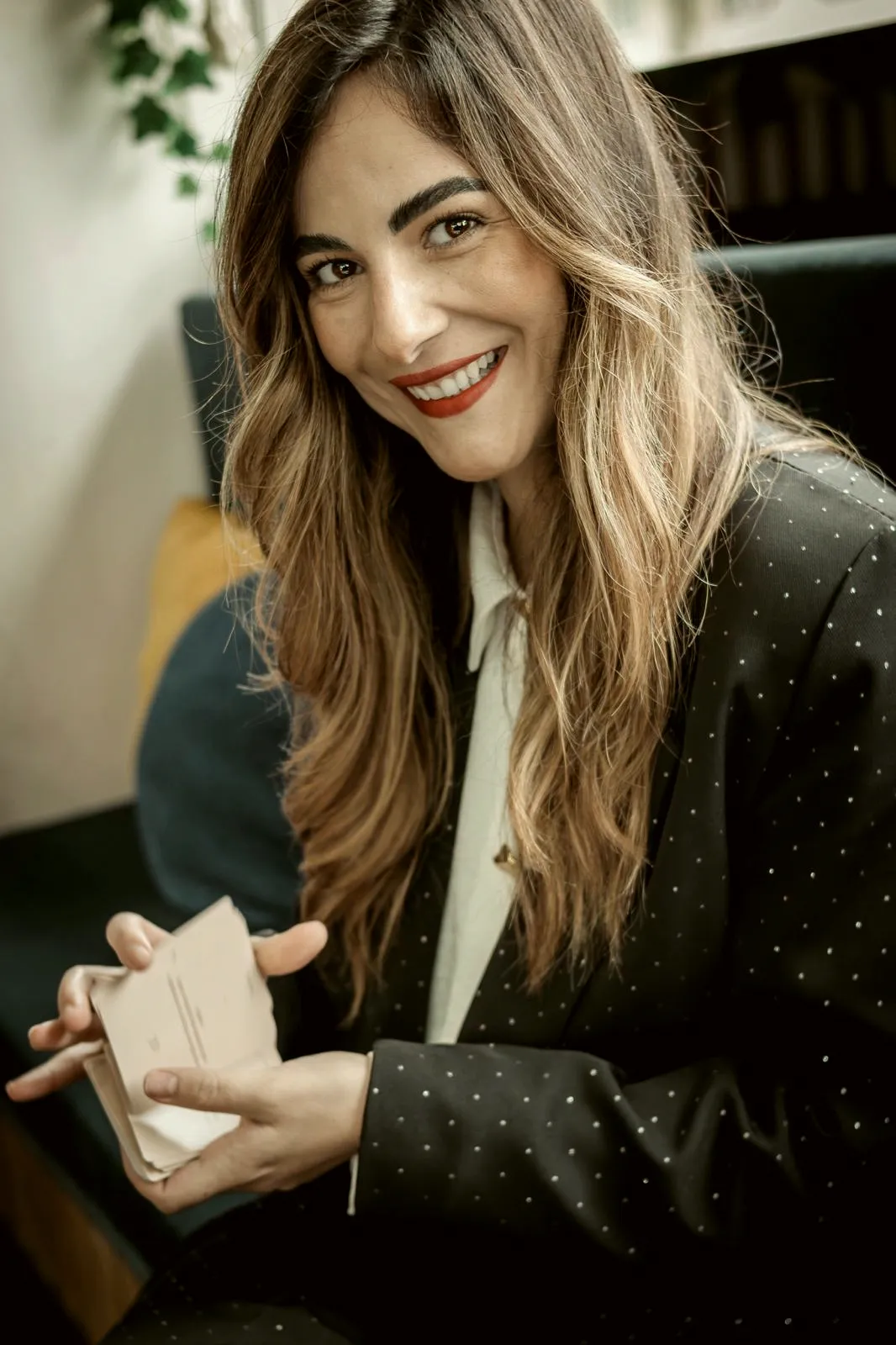 Filipa Jesus a sorrir, com pequenos cartões de papel nas mãos.